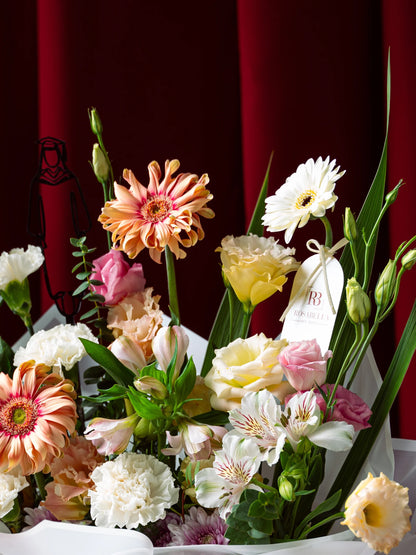 Milestone Blooms Handbag Arrangement with vibrant flowers in an elegant handbag, crafted as graduation flowers, available with delivery to Dubai, Sharjah, and Muwaileh.